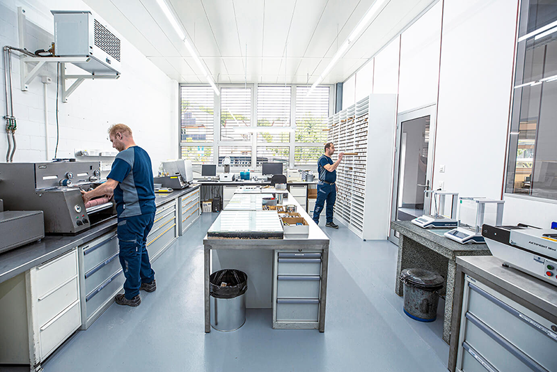 Farblabor von Schaffner GF AG mit Mitarbeitenden, Andruckmaschinen und Farbmusterregalen.