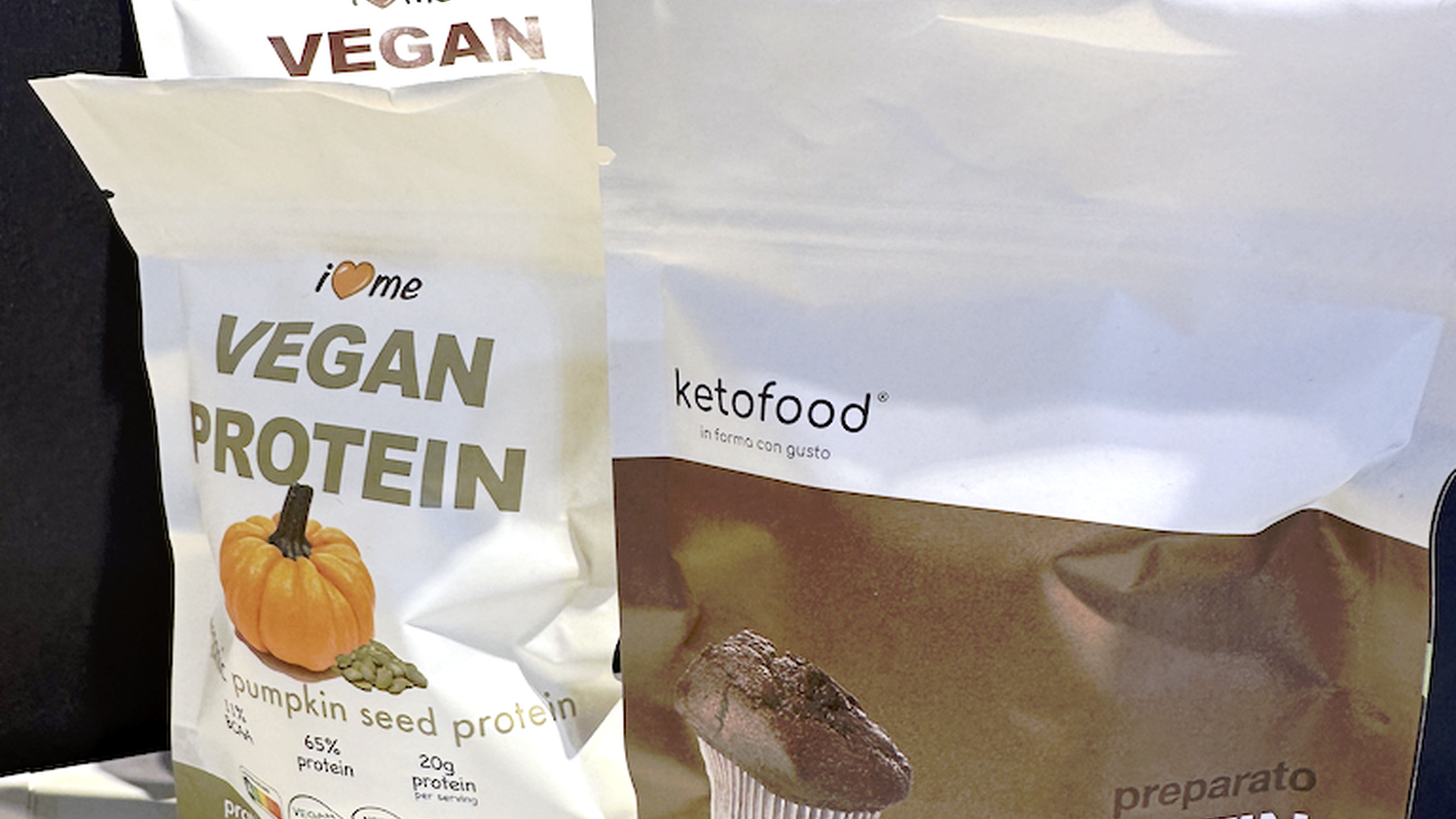Mit TITON-Toner gedruckte Beutel für „Vegan Protein“ und „Ketofood Muffin“ in Weiß und Braun mit klarer Schrift und Produktabbildungen.