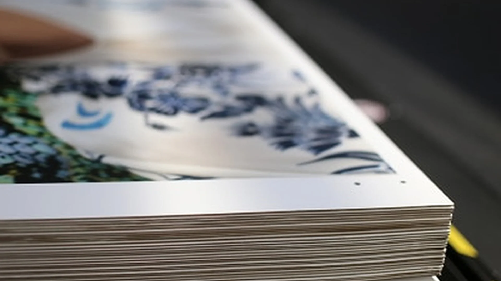 Nahaufnahme eines Stapels bedruckter Kartonplatten mit scharfen Kanten und glänzender Oberfläche.